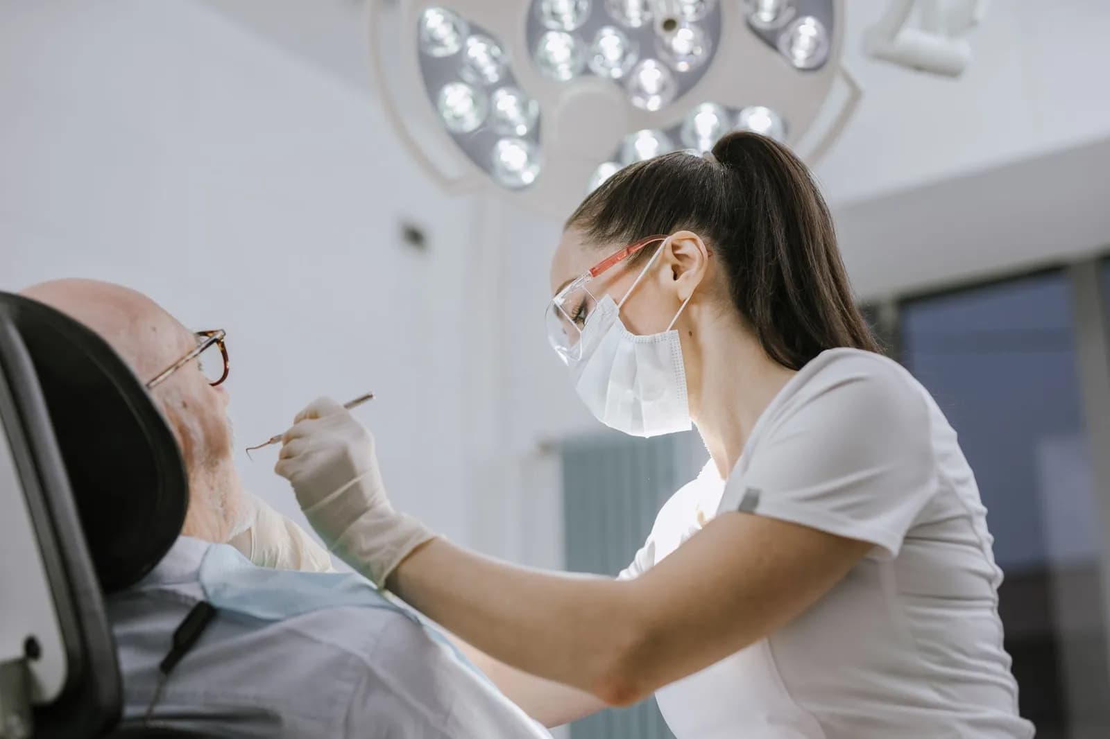 Professional dentist examining patient using dental tools in a clinic.
