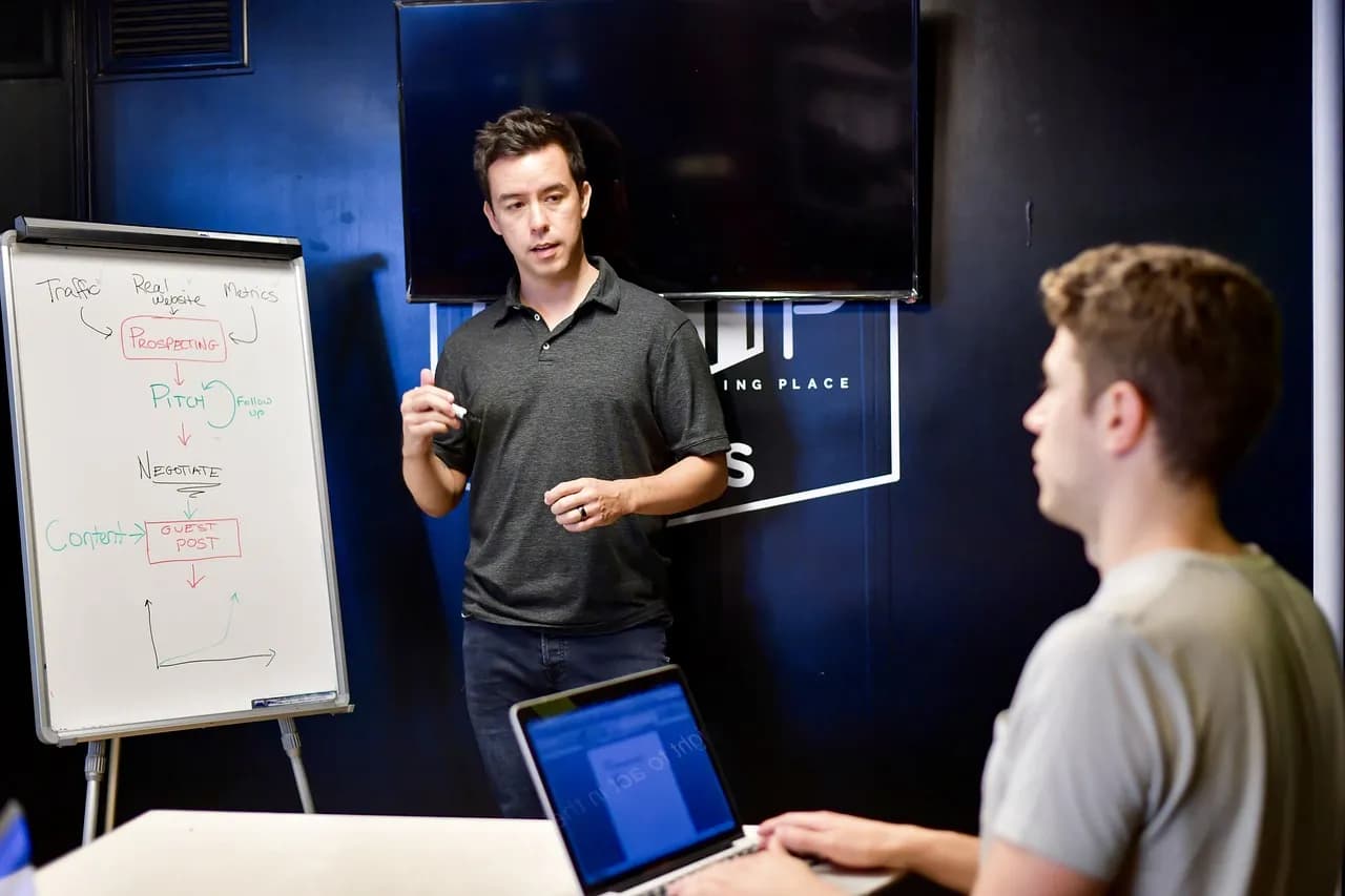 Person holding a notebook with planning details and graph for business strategy indoors.