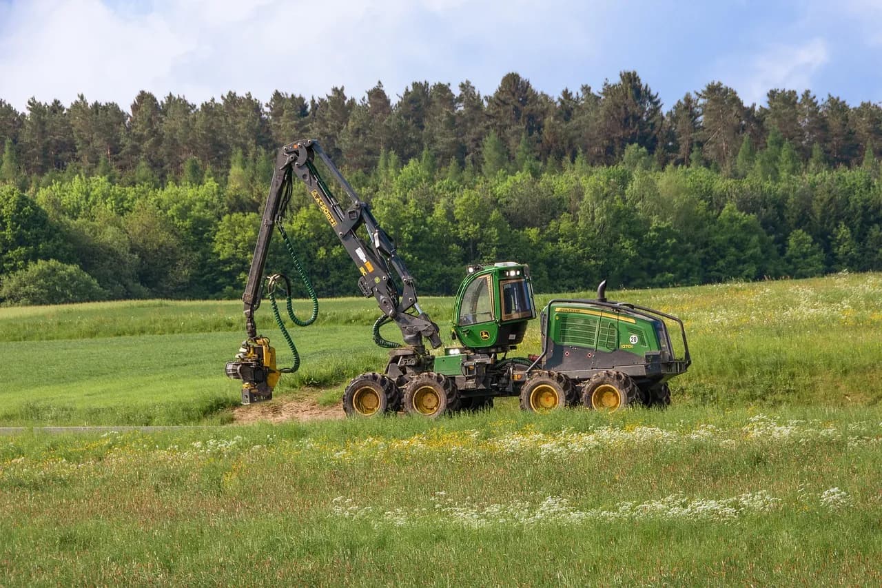 Close-up of a logging machine in action cutting a large tree stump outdoors.