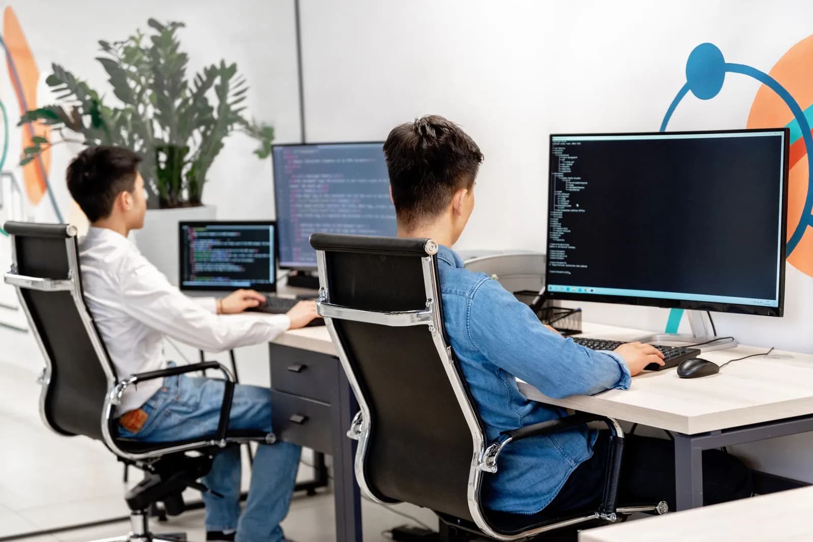 Close-up of laptop with coding software and a motivational coffee mug on a desk.