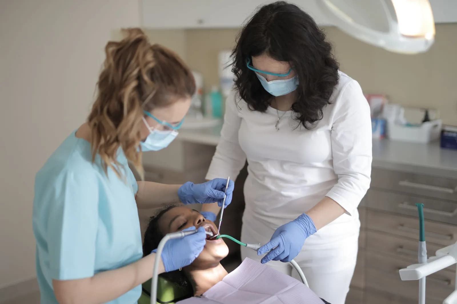 Dental professionals in action within a modern clinic, treating a patient.