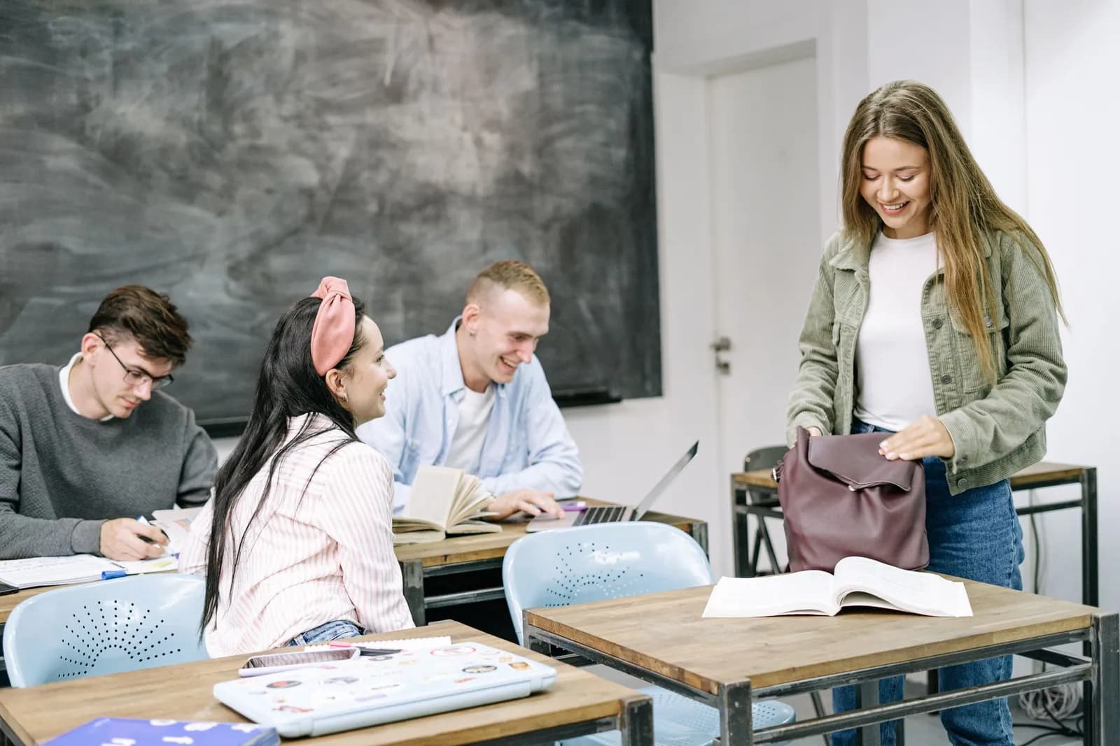 Students wearing masks studying diligently in a classroom with social distancing measures.