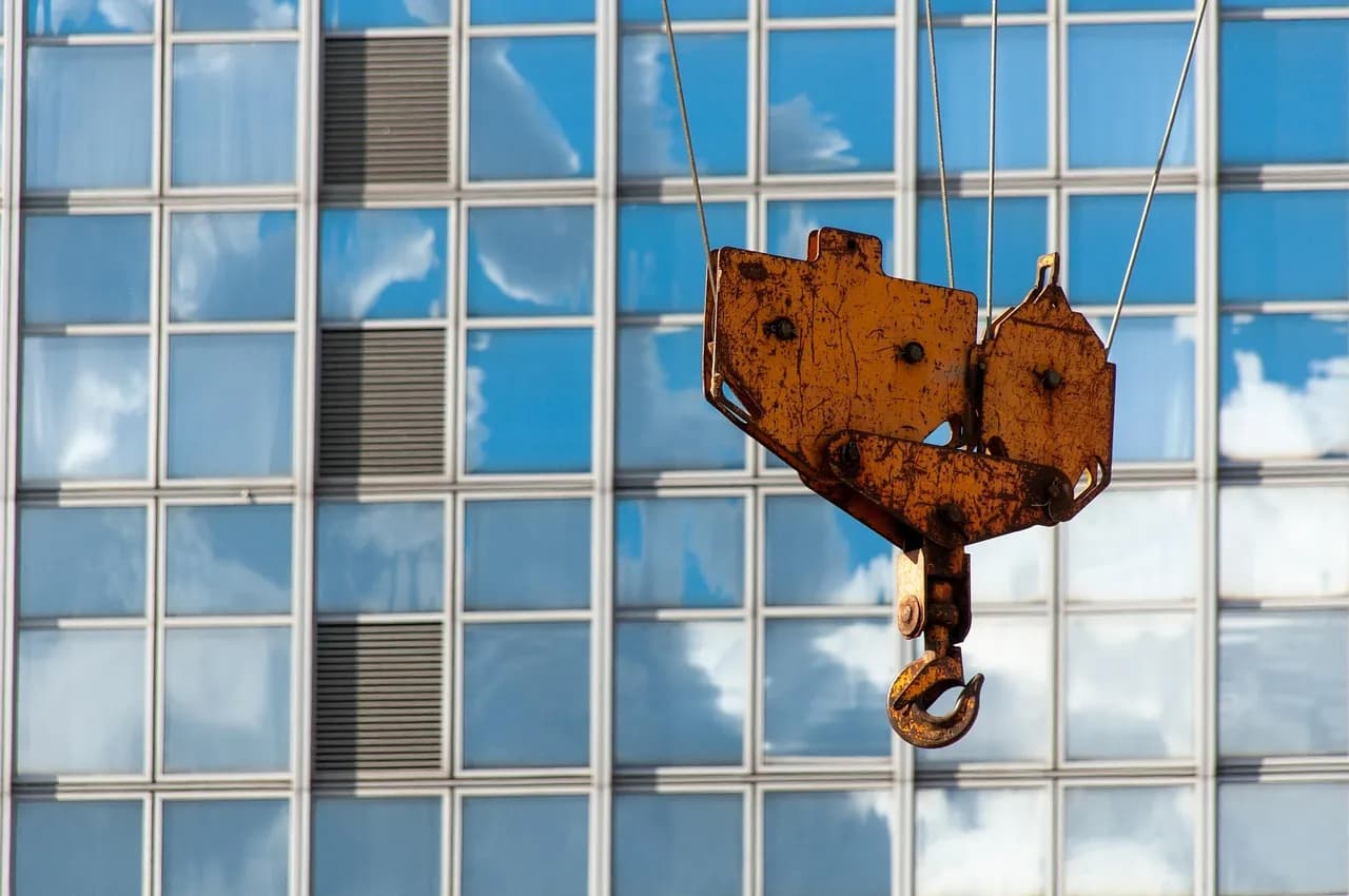 A dynamic view of a construction site with crane and scaffolding on a sunny day.