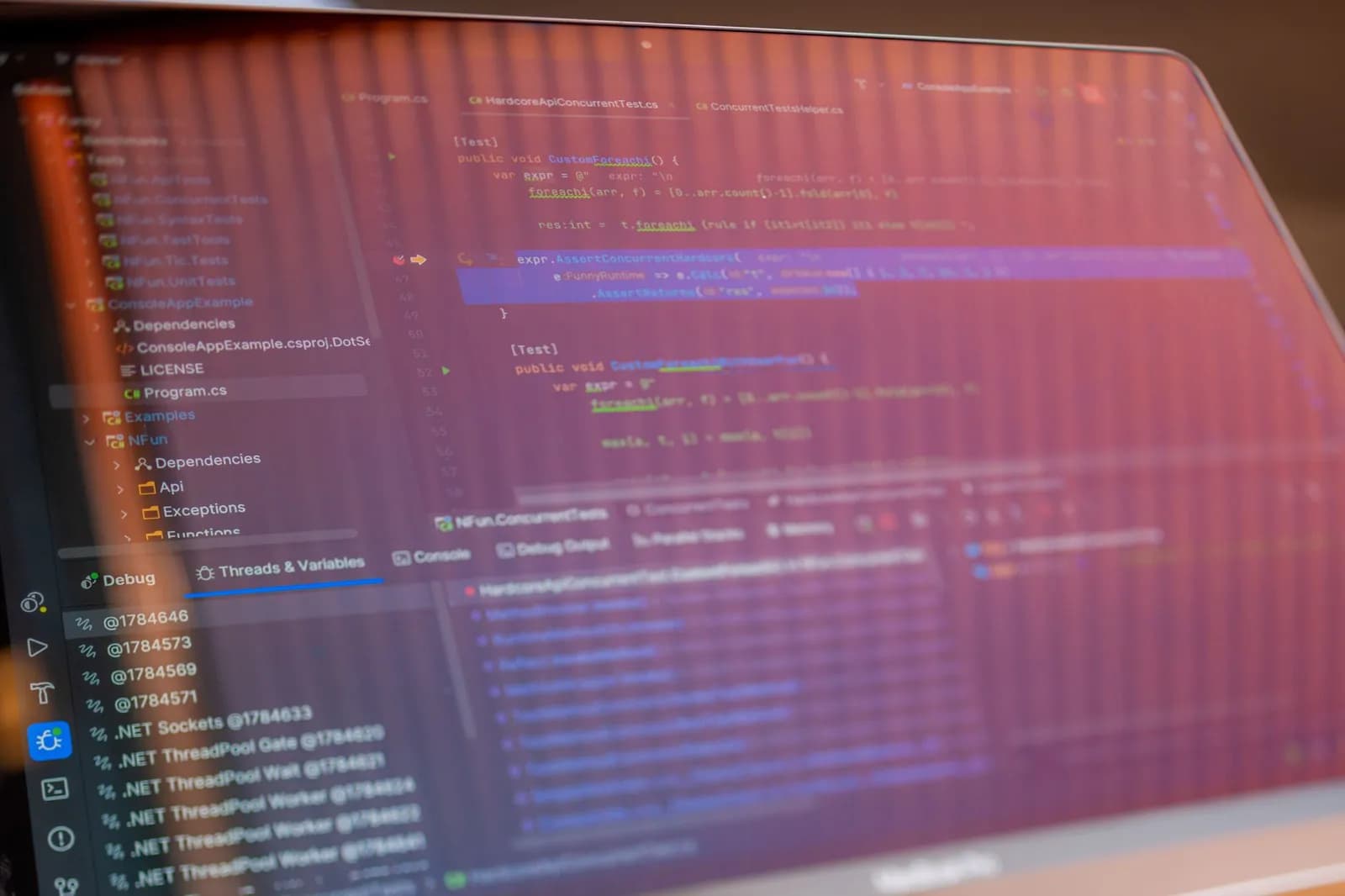 Focused view of a computer screen displaying programming code with visible reflections.