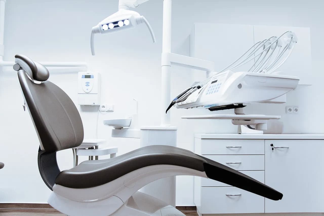 Closeup of a dentist holding a dental prosthetic in a clinical setting, emphasizing prosthodontic care.