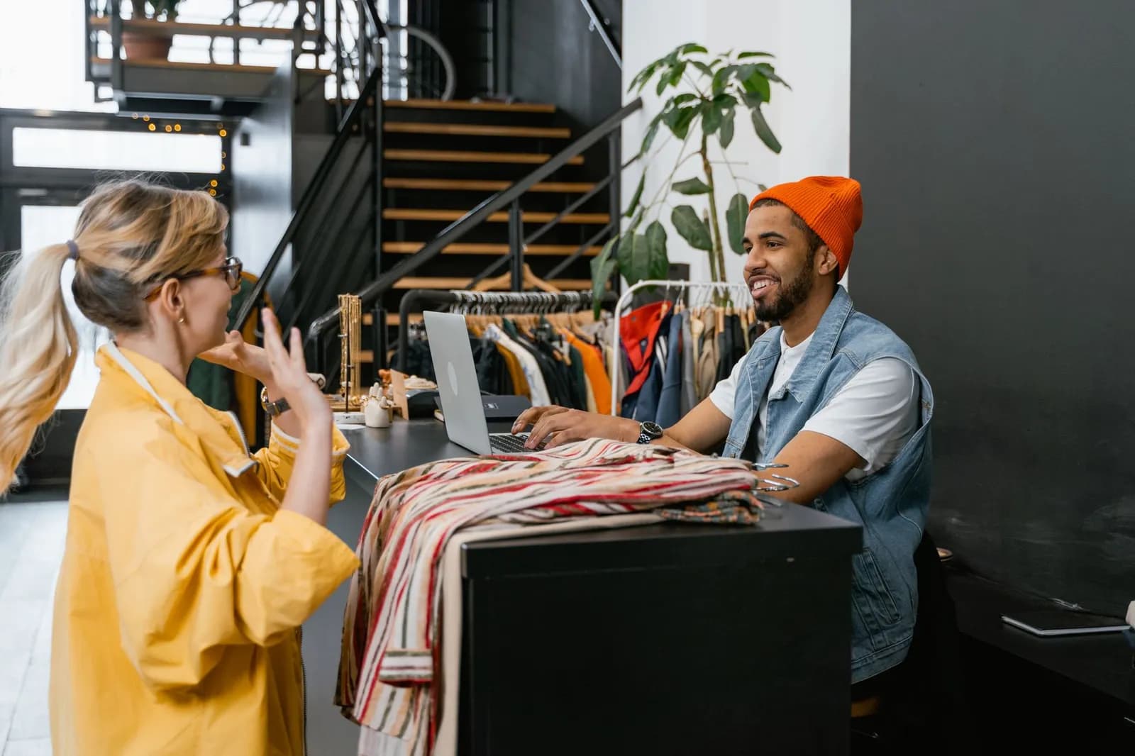 Stylish woman browsing clothes in a modern fashion boutique.