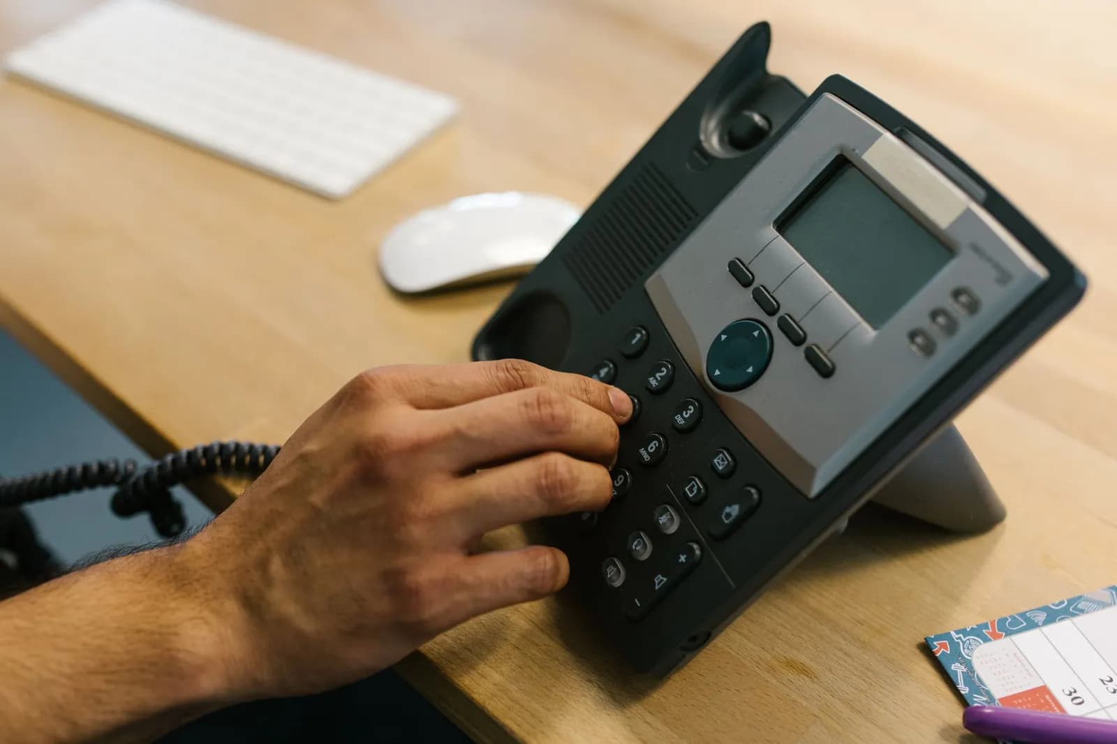 Tree service marketing automation: an arborist trimming a tree while the office phone goes unanswered