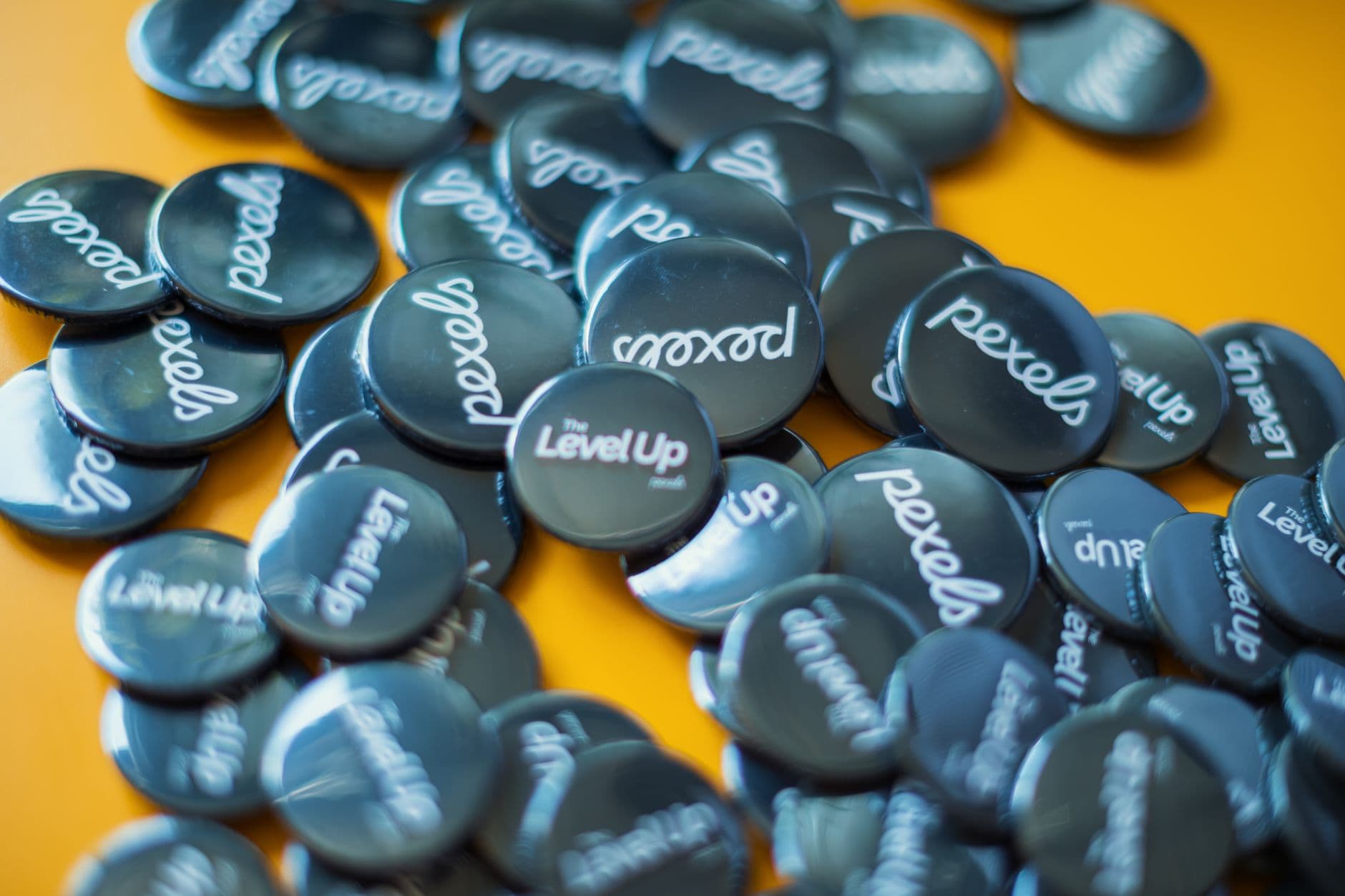 Scattered Pexels and Level Up badges on vibrant yellow surface, showcasing branding.