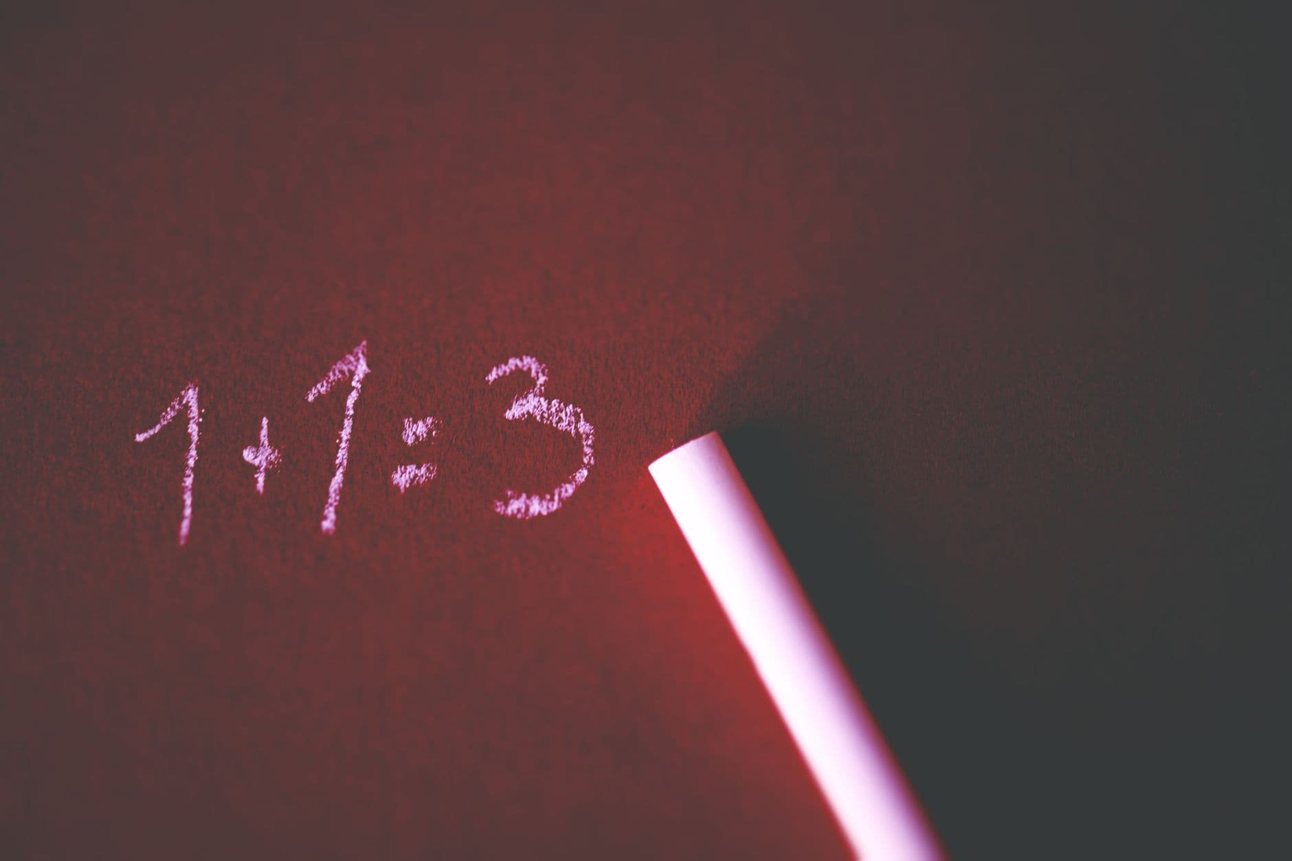 Close-up of a chalkboard with a humorous math error showing 1+1=3 written in chalk.