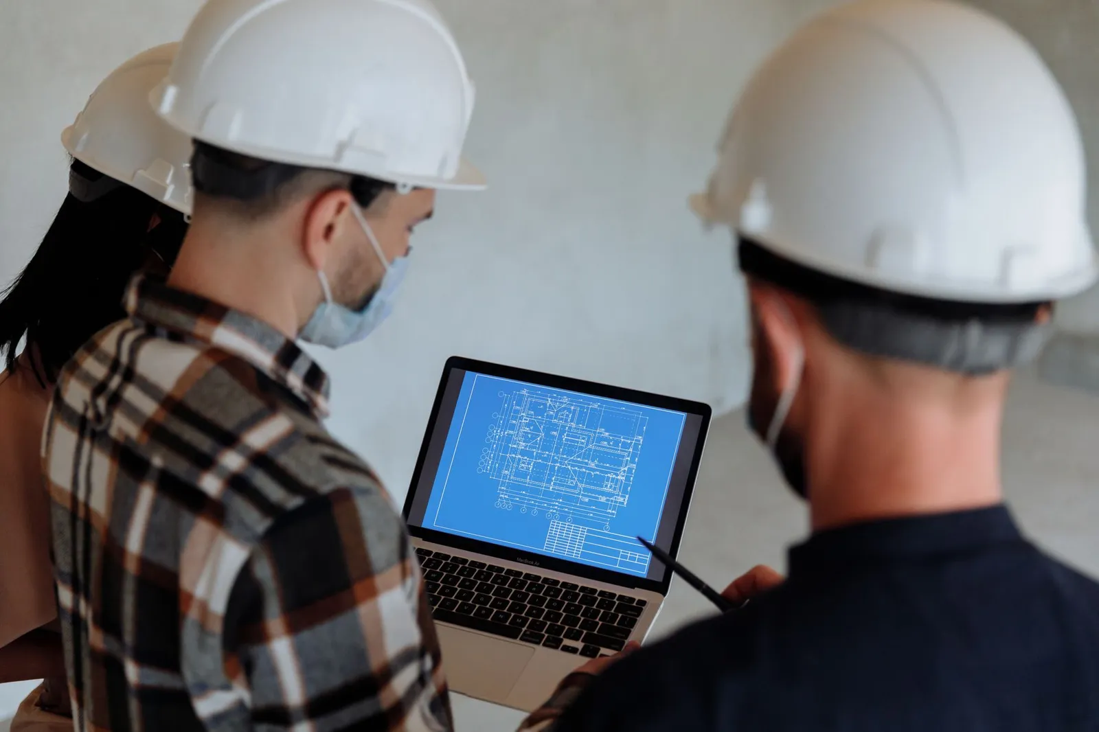 Senior engineer in safety gear holding blueprints, symbolizing experience and dedication in civil engineering.