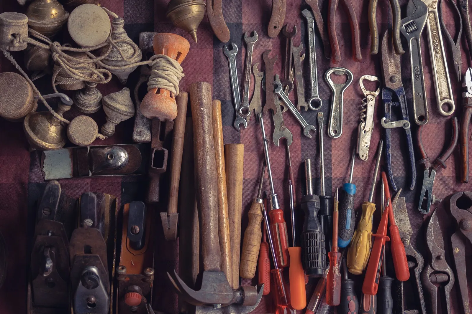 Collection of vintage tools arranged in a flat lay in a workshop setting.