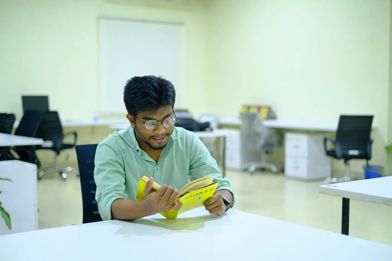 Man reading a book at a modern office in Sylhet, Bangladesh.