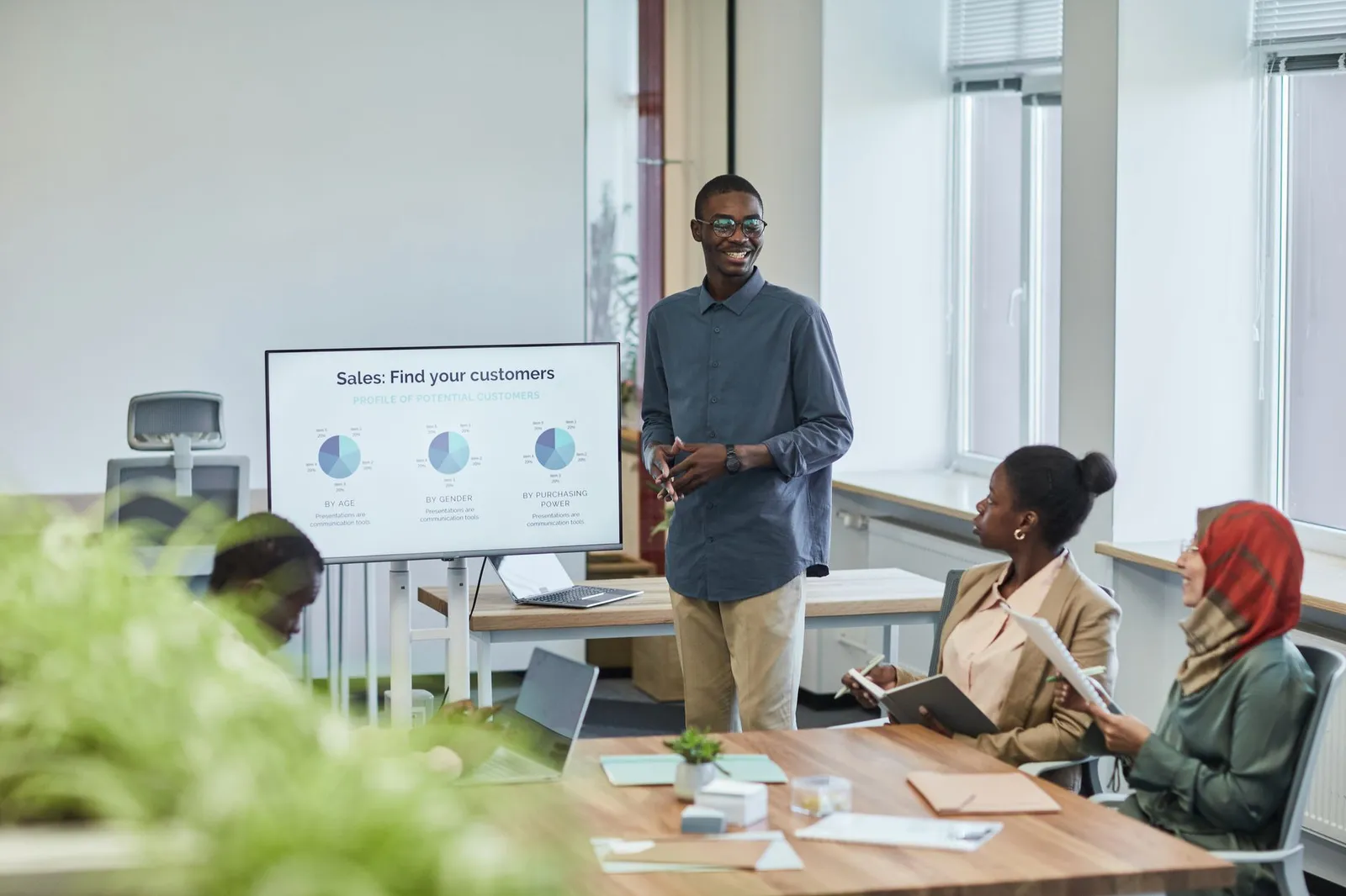 CRM for lead generation reviewed by a sales team around an office screen