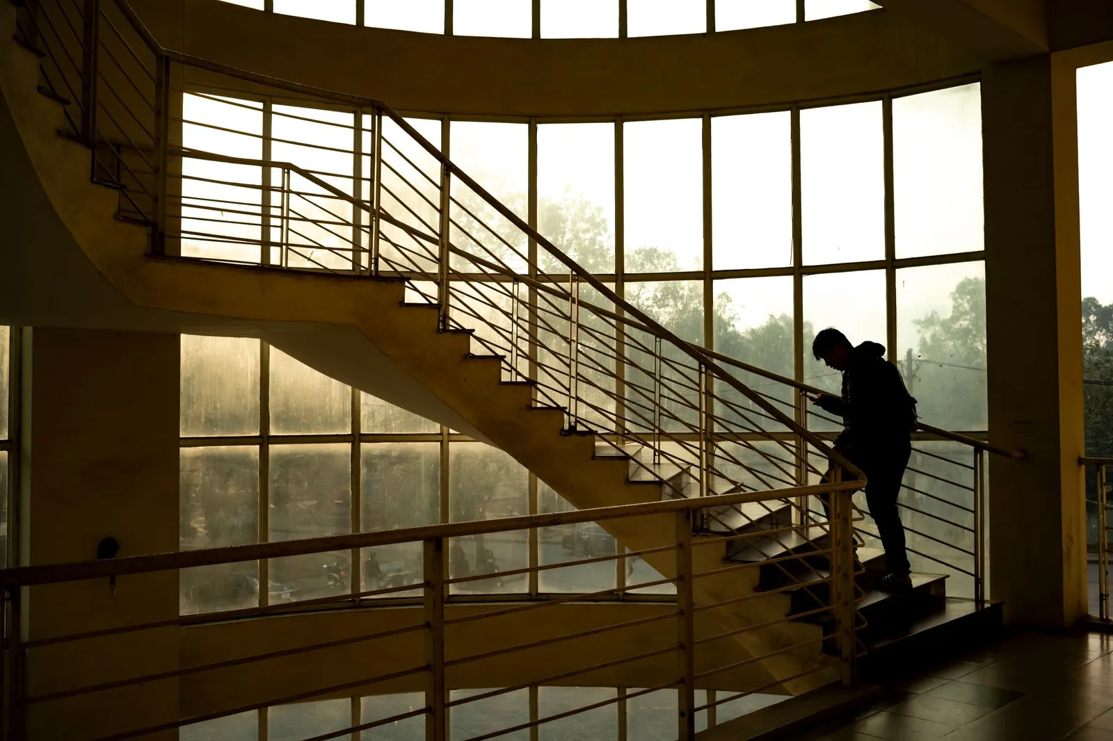 A lone silhouette walks near a staircase in Ankara, Türkiye, casting a dramatic shadow.