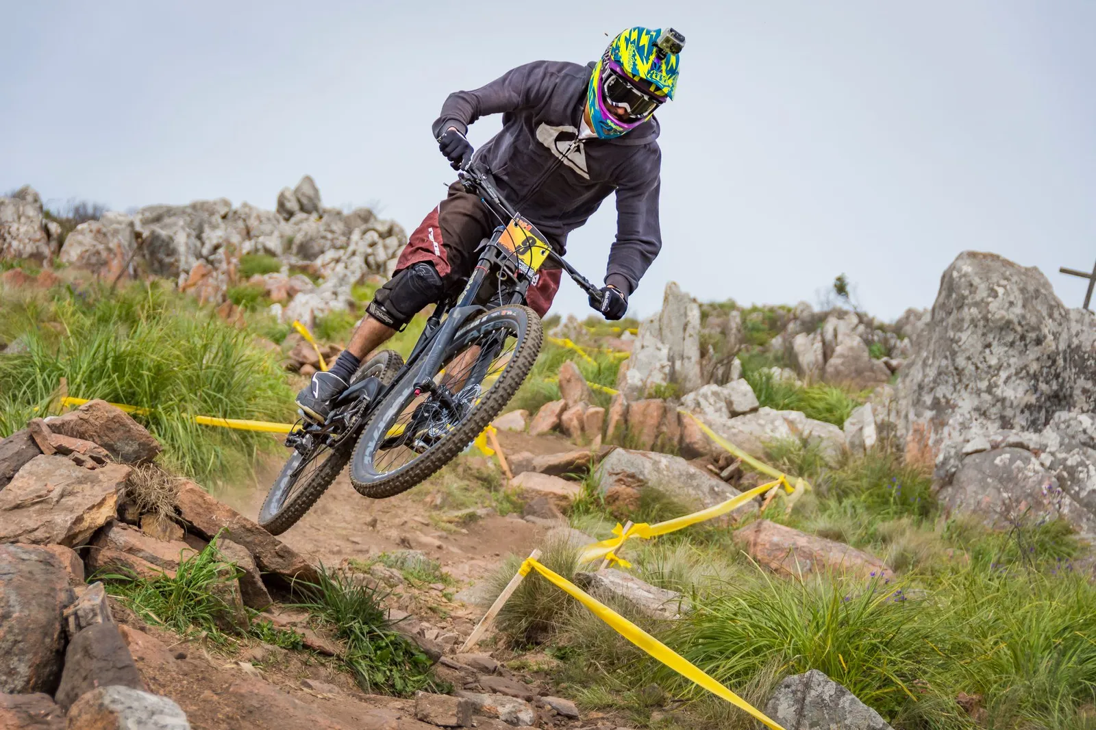 Cyclist racing on a mountain bike on a winding road during the day.