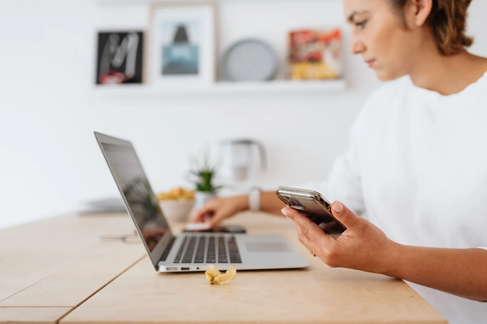 Smartphone displaying Alipay app on open laptop with online shopping site.