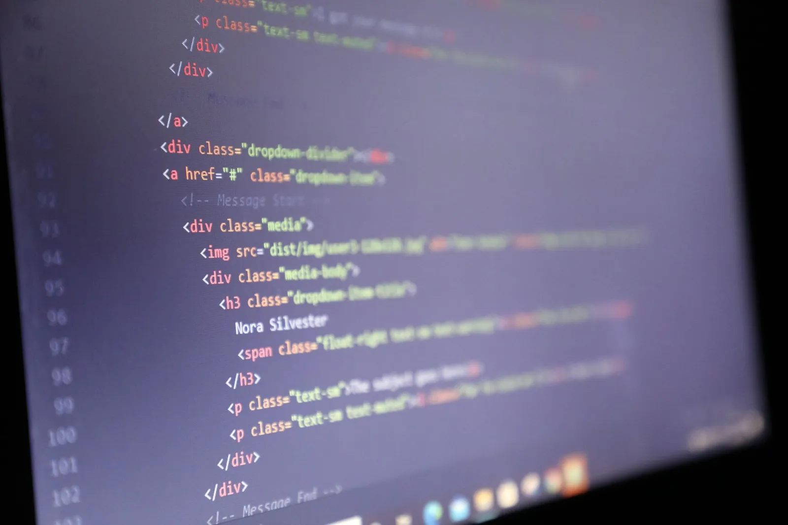 Illuminated HTML code displayed on a computer screen, close-up view.