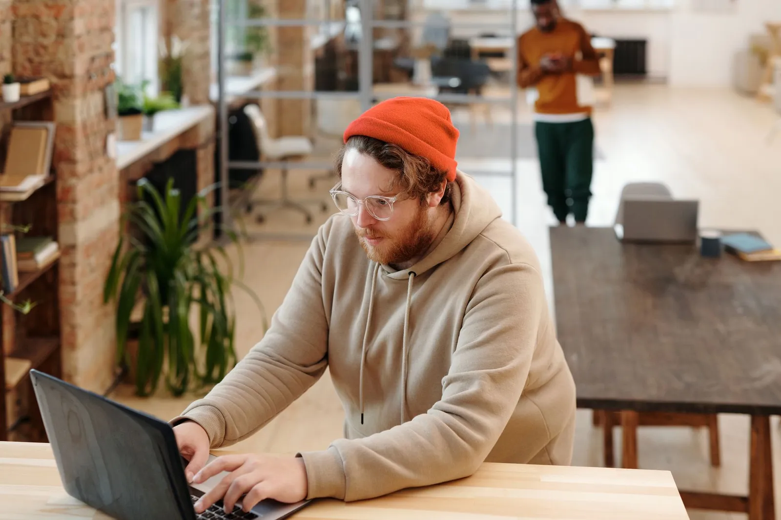 Side profile of a man in a hoodie, surrounded by red code, depicting cybersecurity theme.