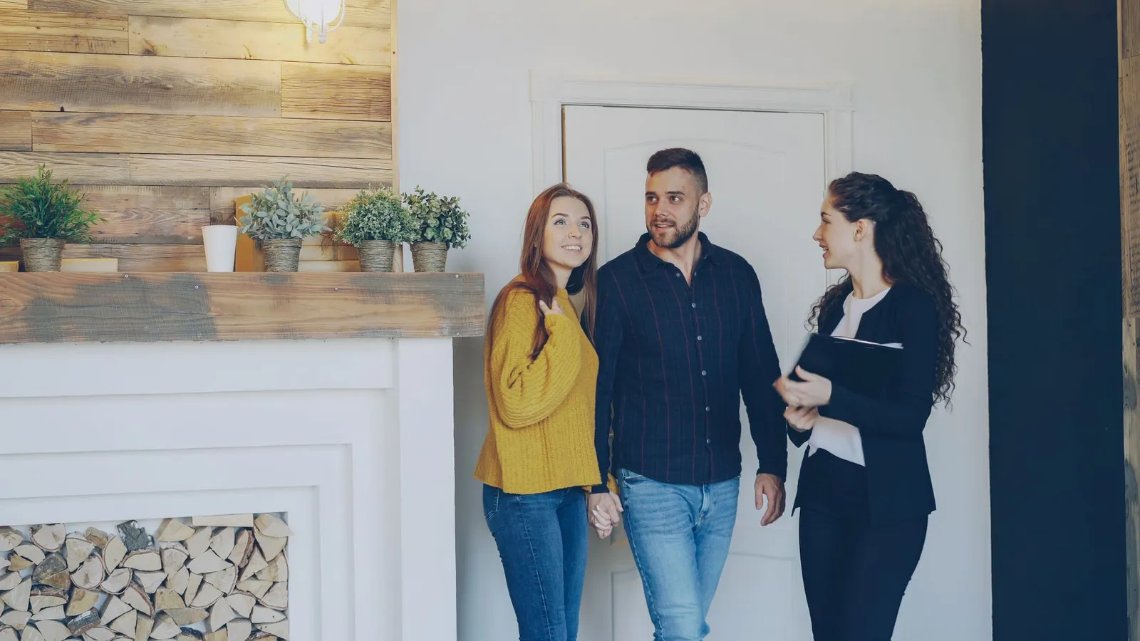 Young couple exploring a new home with their real estate agent, discussing options and features.