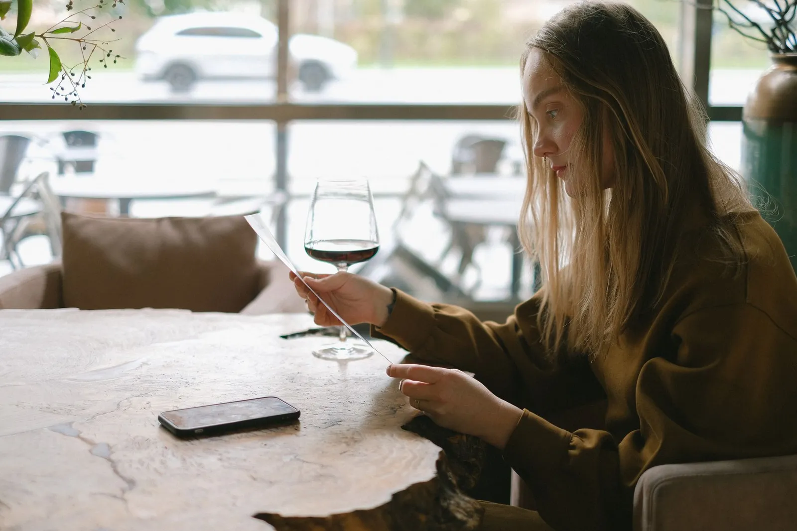A person looking through a restaurant menu indoors, showcasing food selection.
