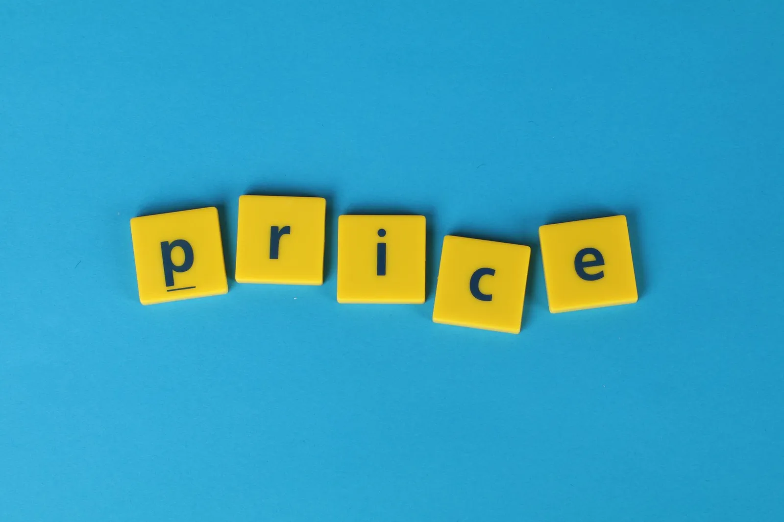 Yellow letter tiles spell the word 'price' against a vibrant blue backdrop, ideal for business concepts.